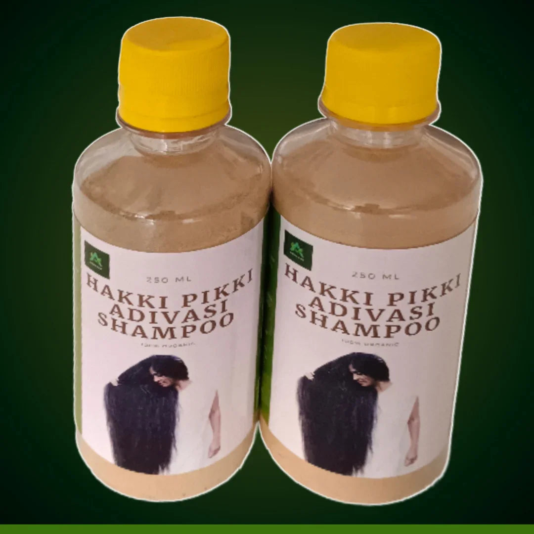 Two bottles of Hakki Pikki Adivasi shampoo with yellow caps and clear labels showing hair care branding